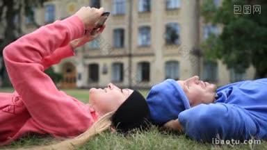 快乐<strong>的</strong>年轻学生夫妇头靠在草地上放松学习后<strong>微笑的</strong>大学生休息